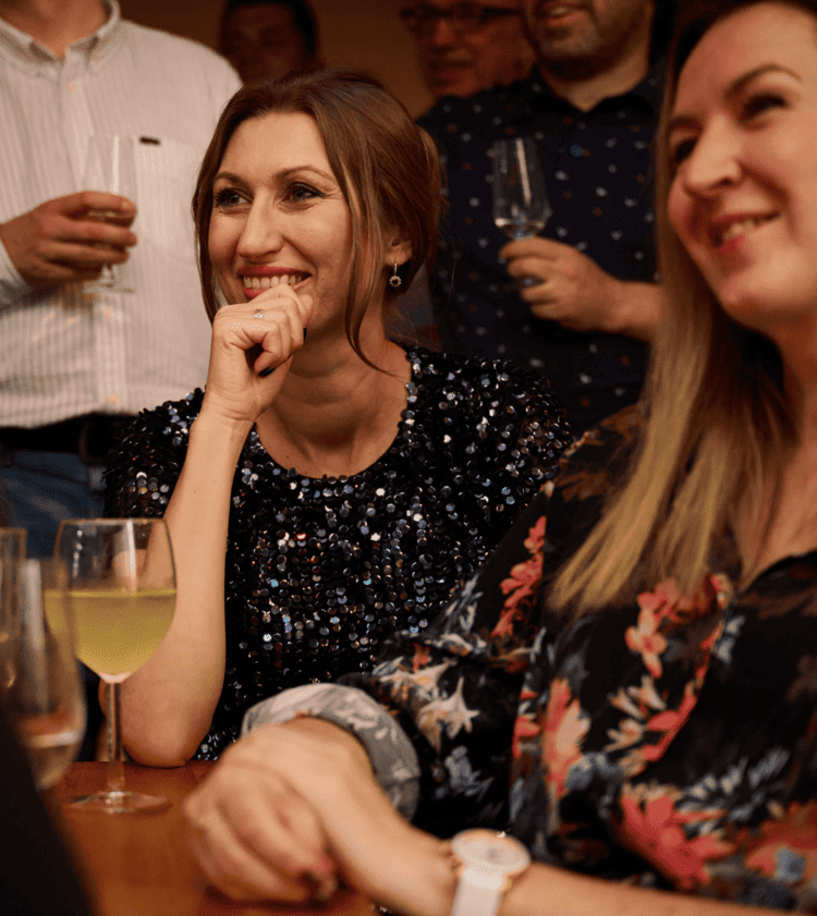 Uśmiechnięci goście podczas pokazu iluzji na imprezie firmowej